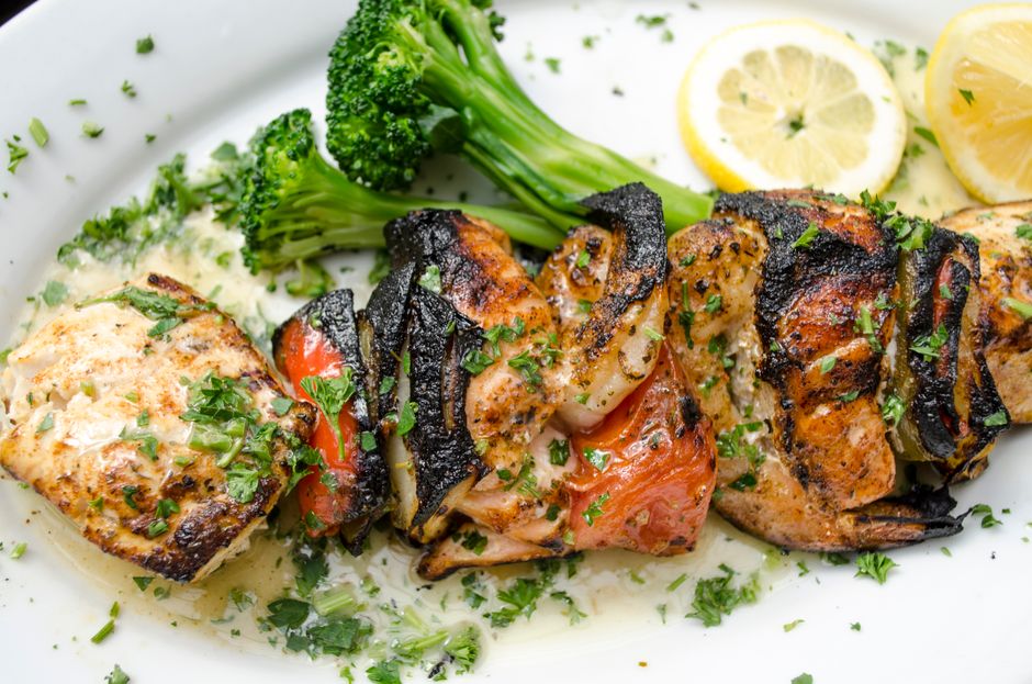 Grilled seafood skewers with vegetables and lemon